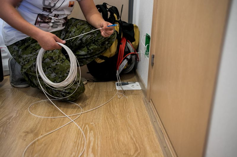 Un technicien installe la fibre de bouygues dans un appartement