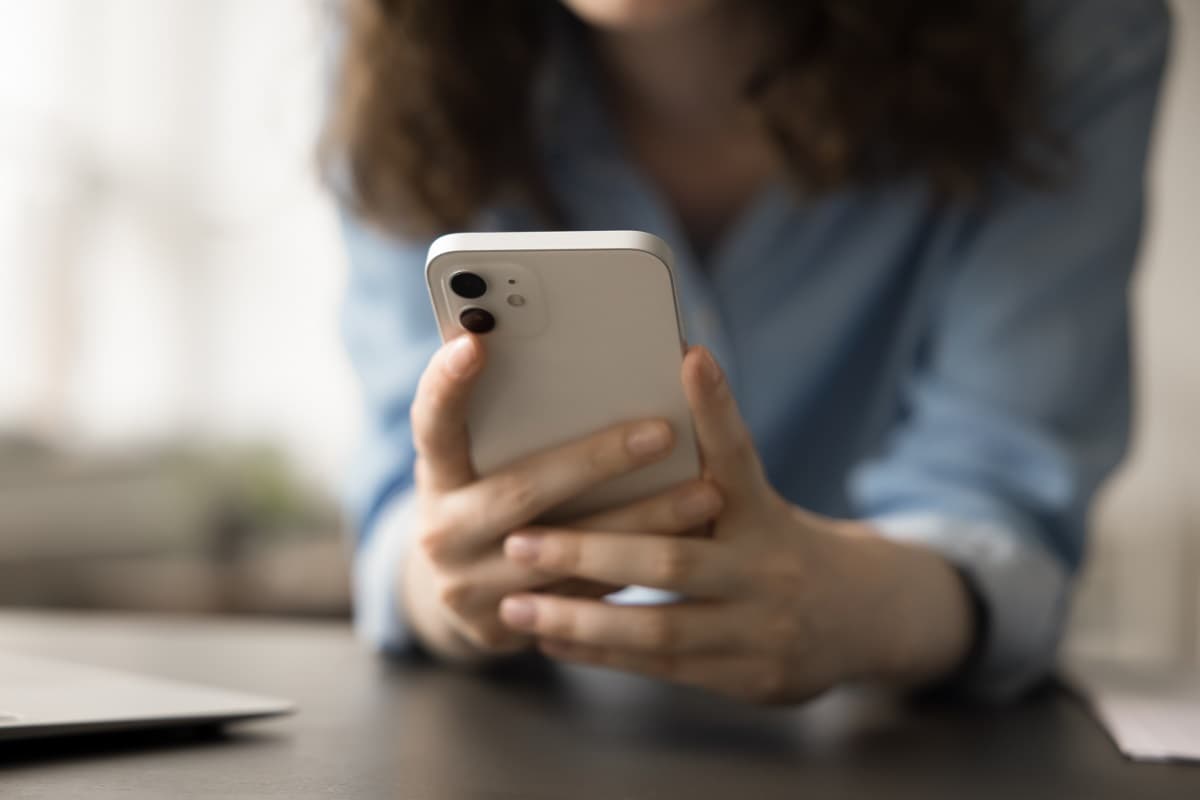 Femme tient smartphone dans les mains, avec forfait suffisant de Lebara à 5€ les 40 Go