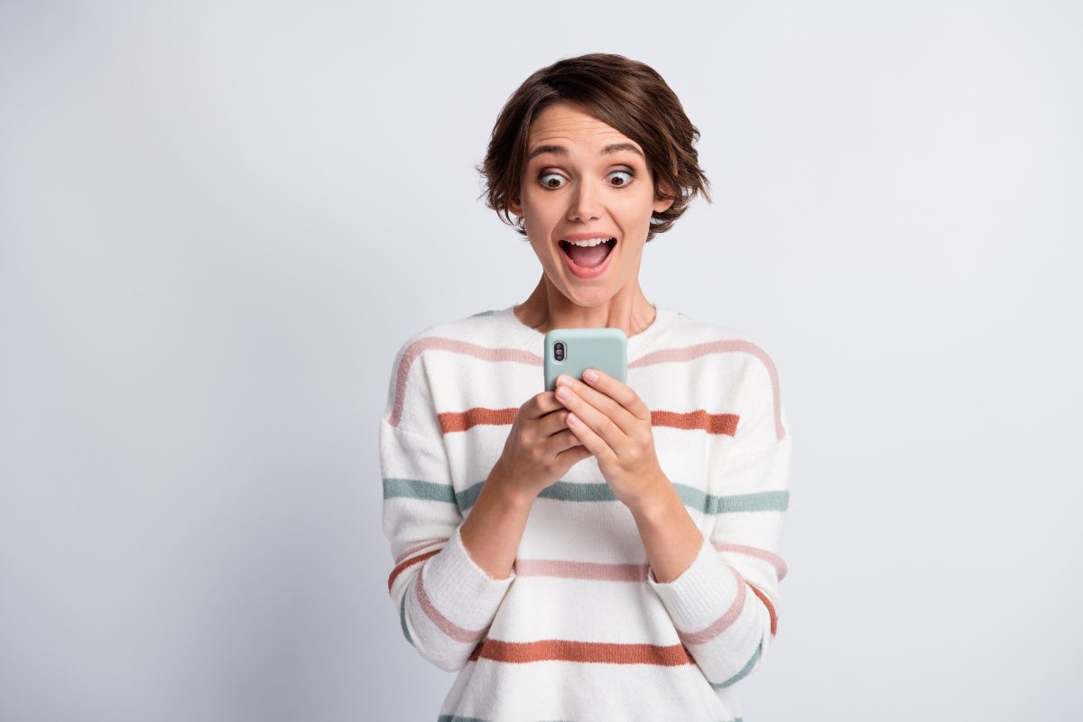 Femme avec smartphone dans les mains super heureuse avec nouveau forfait de YouPrice à 8.99€/mois