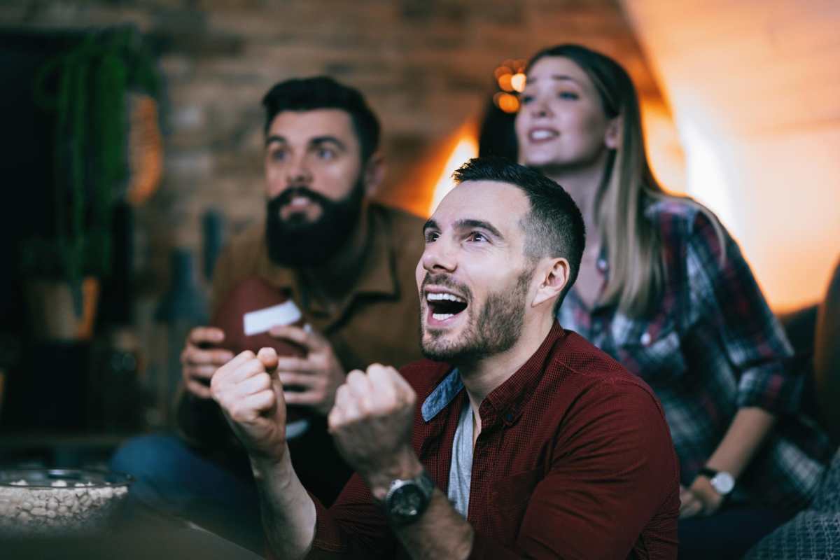 3 personnes regardant du sport à la TV