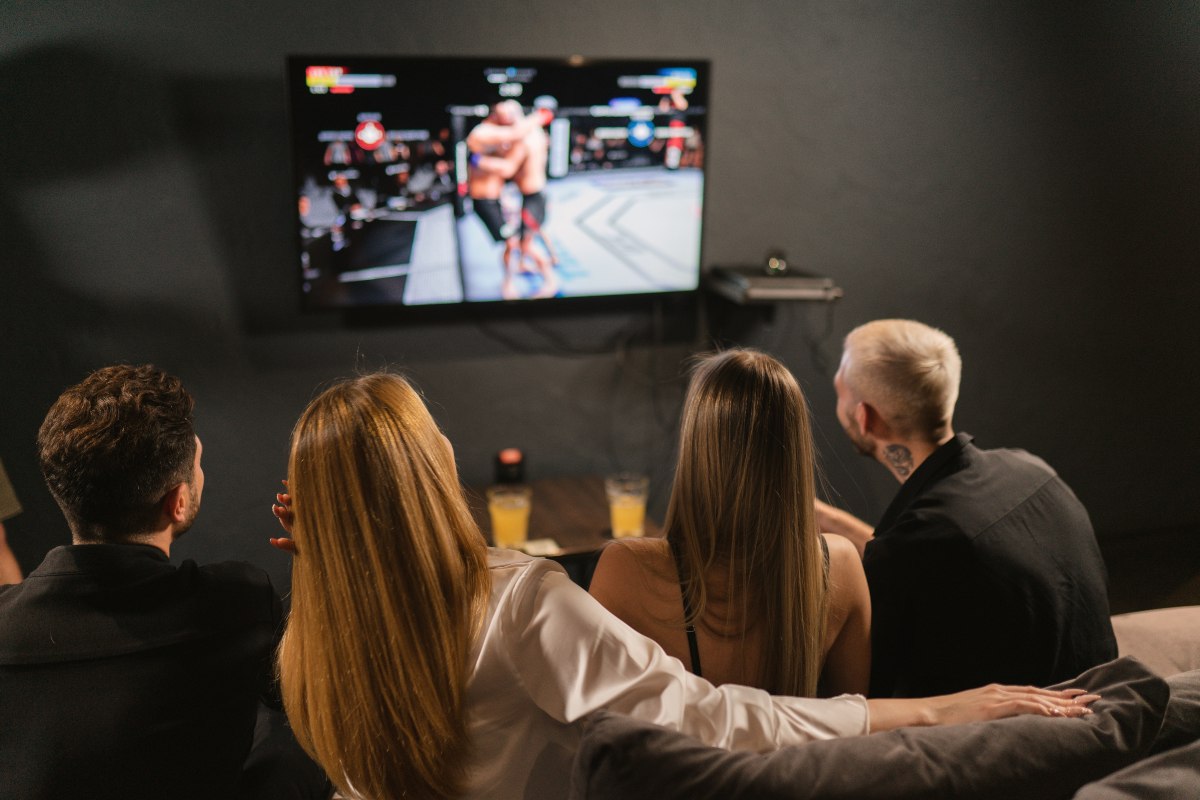 Des amis regardent un combat à la TV